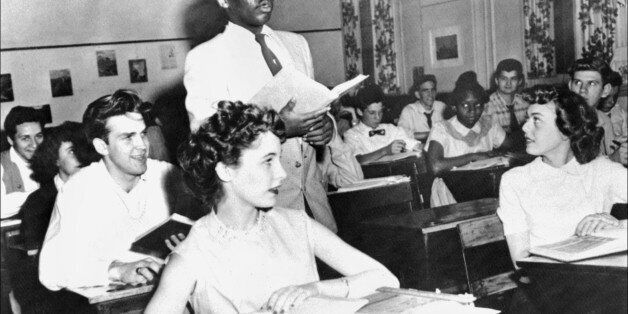 A black student, Nathaniel Steward, 17, recites his lesson surrounded by white fellows and others black students, 21 May 1954 at the Saint-Dominique school, in Washington, where for the first time in USA the Brown v Board of Education decision which outlaws segregation in state schools is applied. (Photo credit should read STAFF/AFP/GettyImages)