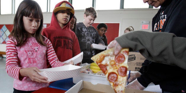 Fairmeadow Elementary School fourth grade student Juliet Lee, left, orders pepperoni pizza during a school lunch program in Palo Alto, Calif., Thursday, Dec. 2, 2010, in Palo Alto, Calif. More children would eat lunches and dinners at school under legislation passed Thursday by the House and sent to the president, part of first lady Michelle Obama's campaign to end childhood hunger and fight childhood obesity. The $4.5 billion bill approved by the House 264-157 would expand a program that provides full meals after school to all 50 states. It would also try to cut down on greasy foods and extra calories by giving the government power to decide what kinds of foods may be sold in vending machines and lunch lines. (AP Photo/Paul Sakuma)