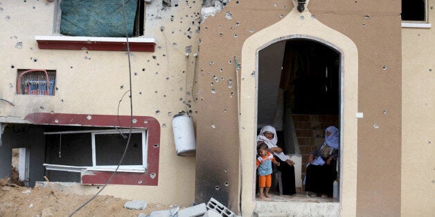 GAZA CITY, GAZA - AUGUST 17: Palestinian women sit among the debris of a building destroyed in Israeli shelling in Johr al-De