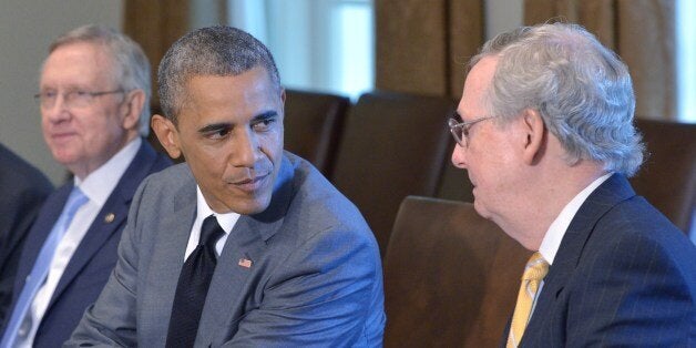 US President Barack Obama (C) looks at Senate Minority Leader Mitch McConnell (R), R-KY, while meeting with members of Congress on foreign policy on July 31, 2014 in the Cabinet Room of the White House in Washington, DC. At left is Senate Majority Leader Harry Reid, D-NV. AFP PHOTO/Mandel NGAN (Photo credit should read MANDEL NGAN/AFP/Getty Images)