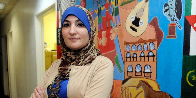 Linda Sarsour, director of the Arab American Association of New York, poses for photos in front of a canvas painted by the association's youth group at its headquarters in the Brooklyn borough of New York, Thursday, Dec. 29, 2011. Sarsour is one of the civic and religious leaders who signed a letter declining an invitation from Mayor Michael Bloomberg to attend an interfaith breakfast in protest of recent revelations about the New York City Police Department's surveillance activities. (AP Photo/Henny Ray Abrams)