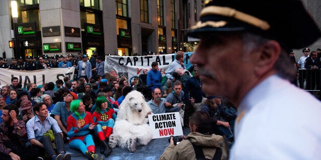 NEW YORK, NY - SEPTEMBER 22: Police officers wait to move in to arrest demonstrators on Broadway following the Flood Wall Street protest after asking them to disperse on September 22, 2014 in New York City. The Flood Wall Street protest came on the heels of the climate change march on September 21 that attracted over 300,000 protestors. (Photo by Bryan Thomas/Getty Images)