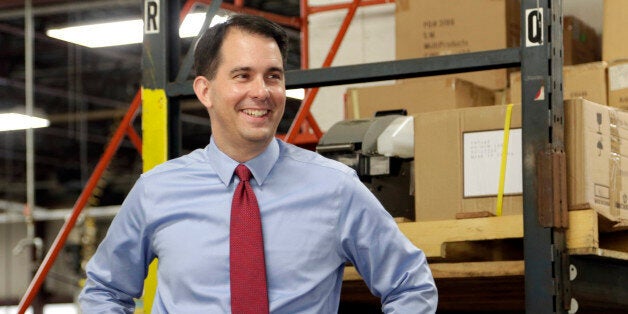 In this Sept. 23, 2014 photo Republican Wisconsin Gov. Scott Walker campaigns for re-election at a manufacturing company in Racine, Wis. The airwaves and campaign appearances in the closely contested governor's race here are bristling with arguments designed to sway opinions before Election Day. But for nearly everyone in Wisconsin, the only issue is Scott Walker. And almost every voter already knows whether they love him or hate him. (AP Photo/Darren Hauck)