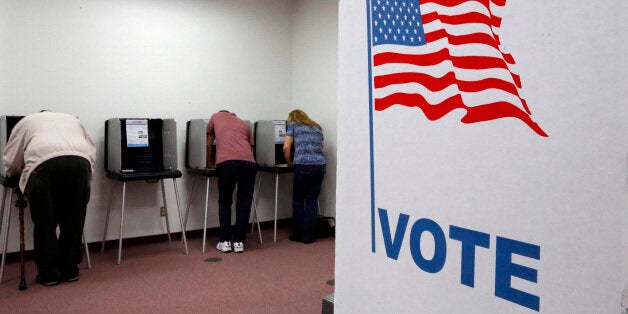 Registered voters cast ballots during the early voting period at the Sangamon County Building Monday, Oct. 20, 2014, in Springfield, Ill. People can cast their ballots from Monday through Nov. 2 at sites around the state. (AP Photo/Seth Perlman)