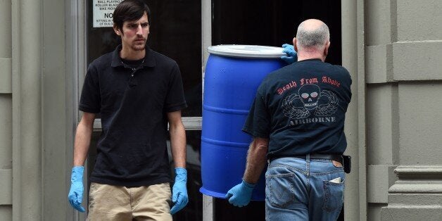 Hazmat crews take barrels into the apartment building of Dr. Craig Spencer, a member of Doctors Without Borders, October 24,
