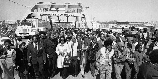 Aided by Father James Robinson, Mrs. Coretta Scott King, widow of Dr. Martin Luther King, Jr., center, and John Lewis of the Voter Education Project, a crowd estimated by police at 5,000, march across the Edmund Pettus Bridge from Selma, Alabama Saturday, March 8, 1975. The march commemorated the decade since the violent struggle for voting rights began in 1965 with âBloody Sundayâ at the bridge as police tried to stop a march to Montgomery. (AP Photo)