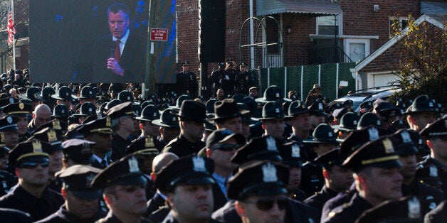 Police officers turn their backs as New York City Mayor Bill de Blasio speaks at the funeral of New York city police officer Rafael Ramos in the Glendale section of Queens, Saturday, Dec. 27, 2014, in New York. Ramos and his partner, officer Wenjian Liu, were killed Dec. 20 as they sat in their patrol car on a Brooklyn street. The shooter, Ismaaiyl Brinsley, later killed himself. (AP Photo/John Minchillo)