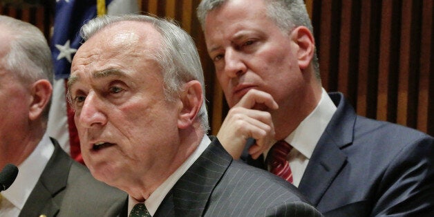 New York Mayor Bill de Blasio, right, listens as New York City Police Commissioner William Bratton addresses a news conference at New York City Police headquarters, Monday, Jan. 5, 2015. De Blasio says it was "disrespectful" that some NYPD officers turned their backs to him during a pair of funerals for slain police officers. (AP Photo/Richard Drew)