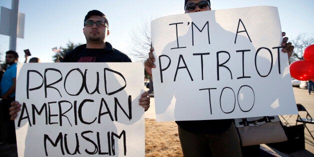 Sharjeel Hassan, left, and Yusuf Alwar,, both of Richardson, Texas, holds signs as they stand with supporters outside the Curtis Culwell Center, Saturday, Jan. 17, 2015, in Garland, Texas. A muslim conference against terror and hate was scheduled at the event center. (AP Photo/Tony Gutierrez)