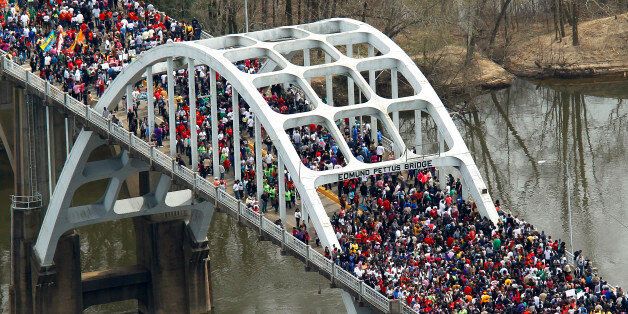 In this aerial view, Crowds of people move in a symbolic walk across the Edmund Pettus Bridge, Sunday, March 8, 2015, in Selma, Ala. This weekend marks the 50th anniversary of "Bloody Sunday,' a civil rights march in which protestors were beaten, trampled and tear-gassed by police at the Edmund Pettus Bridge, in Selma. (AP Photo/Butch Dill)