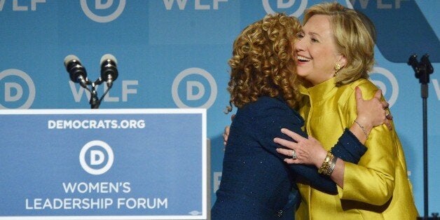 Former US Secretary of State Hillary Rodham Clinton (R) hugs DNC Chair Rep. Debbie Wasserman Schultz (L), D-FL, as Clinton arrives on stage to speak at the Democratic National Committee's Womens Leadership Forum Issues Conference in Washington, DC on September 19, 2014. AFP PHOTO/Mandel NGAN (Photo credit should read MANDEL NGAN/AFP/Getty Images)