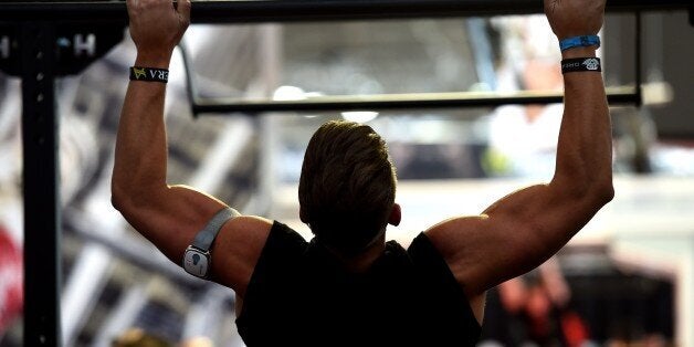 A man does workout with a handle bar at the FIBO international trade show for fitness, wellness and health in Cologne, western Germany, on 10 April, 2015. The show opened on April 9 and will run until April 12, 2015. AFP PHOTO / PATRIK STOLLARZ (Photo credit should read PATRIK STOLLARZ/AFP/Getty Images)