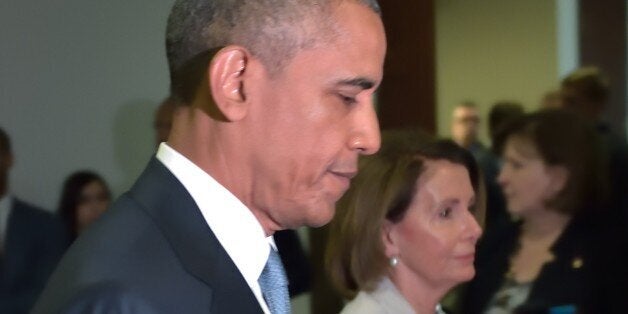 US President Barack Obama and House Minority Leader Nancy Pelosi walk through a hallway after meeting with House Democrats at the US Capitol on June 12, 2015 in Washington, DC. President Barack Obama Friday went to Congress Friday for a frantic round of lobbying ahead of a crucial vote on his sweeping trans-Pacific trade agenda. The House of Representatives is expected to vote mid-day Friday on final passage of so-called Trade Promotion Authority, and while Republican leaders are confident they have the momentum to get it across the finish line, the vote remains a toss-up. AFP PHOTO/MANDEL NGAN (Photo credit should read MANDEL NGAN/AFP/Getty Images)