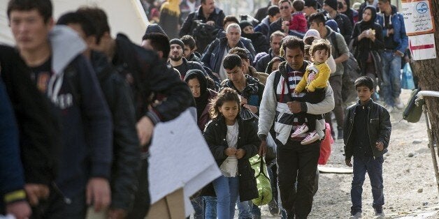 Migrants and refugees cross the Greek-Macedonian border near Gevgelija on November 10, 2015. More than 3,000 refugees and mig