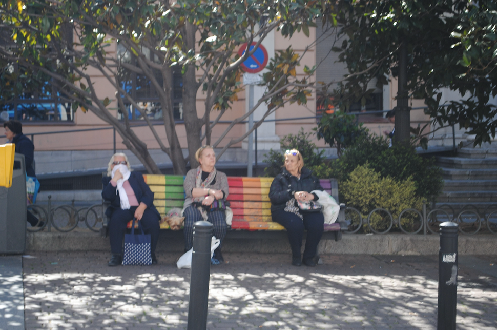 Um dia antes de o governo espanhol limitar circula&ccedil;&atilde;o, mulheres descansam em pra&ccedil;a p&uacute;blica.