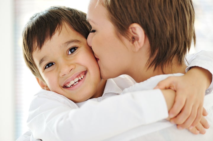 Happy mother embracing and kissing her son