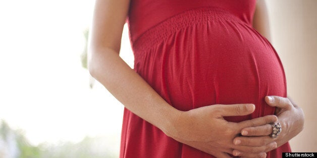Image of pregnant woman touching her belly with hands