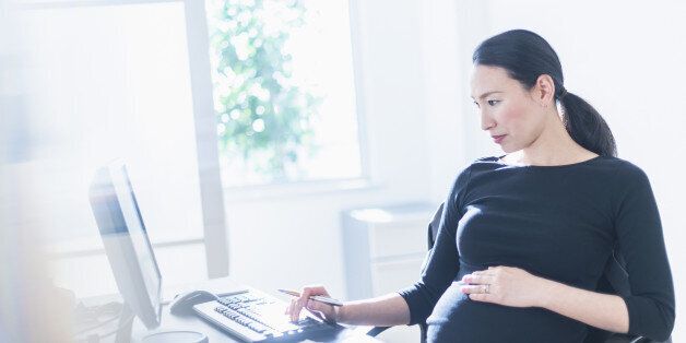 Pregnant Japanese businesswoman using computer