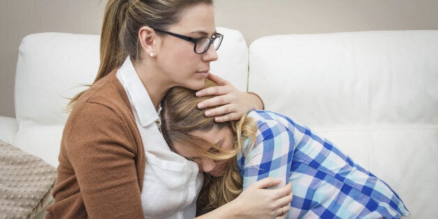 Mother embracing and soothes depressed teen daughter by problems