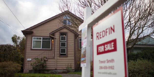 A Redfin Corp. 'For Sale' sign stands outside of a home in Seattle, Washington, U.S., on Tuesday, Nov. 19, 2013. Purchases of previously-owned U.S. homes fell in October to the lowest level in four months as limited supply and higher mortgage rates restrained momentum in the housing-market recovery. Photographer: David Ryder/Bloomberg via Getty Images
