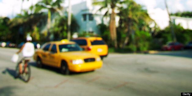 Defocus view of tropical Miami scene with bright yellow taxis and palm trees