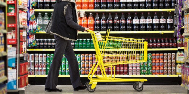 Customer Wendy Rosen pushes a shopping cart past a display of soft drinks at a Dollar General Corp. store in Saddle Brook, New Jersey, U.S., on Saturday, Dec. 3, 2011. Dollar General is scheduled to announce earnings results on Dec. 5. Photographer: Emile Wamsteker/Bloomberg via Getty Images