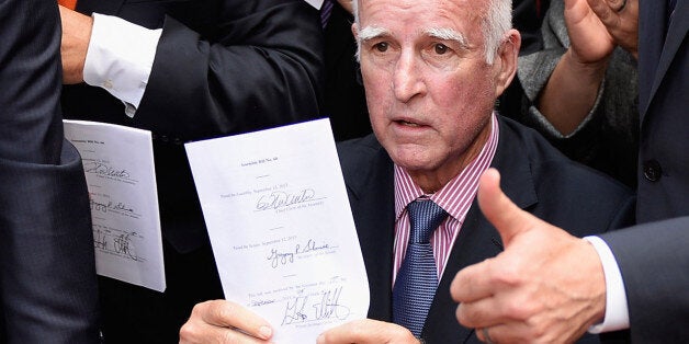 LOS ANGELES, CA - OCTOBER 03: California Governor Jerry Brown celebrates after signing bill AB60 on the steps of Los Angeles City Hall October 3, 2013 in Los Angeles, California. California Assembly Bill 60 also known as the Safe and Responsible Driver Act allows illegal immigrants to receive a permit to legally drive in California. (Photo by Kevork Djansezian/Getty Images)