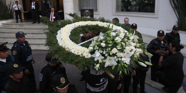 A man arrives with flowers to the funeral home where the body of Colombian author Gabriel Garcia Marquez was taken in Mexico City, Thursday, April 17, 2014. Garcia Marquez died on Thursday at his home in Mexico City. The Nobel laureate's magical realist novels and short stories exposed tens of millions of readers to Latin America's passion, superstition, violence and inequality. (AP Photo/Marco Ugarte)