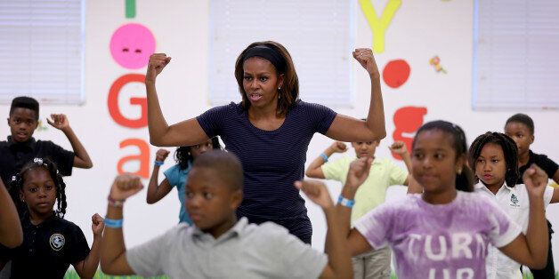 MIAMI, FL - FEBRUARY 25: First Lady Michelle Obama participates in a yoga class during a visit to the Gwen Cherry Park NFL/YET Center on February 25, 2014 in Miami, Florida. The visit was part of a celebration around the fourth anniversary of Lets Move!, her initiative to ensure that all our children grow up healthy and reach their full potential. (Photo by Joe Raedle/Getty Images)