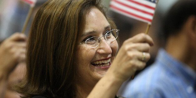 LOS ANGELES, CA - AUGUST 28: Sania Stiles, who came to the US from Monterrey, Mexico eight years ago, waves a flag upon gaining US citizenship as 18,418 people are sworn in as US citizens during naturalization ceremonies at the Los Angeles Convention Center on August 28, 2008 in Los Angeles, California. Immigrants, especially Latinos, which now make up 15 percent of the US population, play an increasingly important role in US politics. Democratic presidential candidate Barack Obama (D-IL), who could benefit from a strong Hispanic following of former presidential hopeful Sen. Hillary Clinton (D-NY), who now campaigns for him, has set aside $20 million for Latino outreach. Republican rival John McCain has also stepped up efforts to attract Latinos, focusing particularly on those in the military. The US Department of Homeland Security reports that citizenship applications have jumped by more than 100 percent since 2006, a surge in naturalization that is expected to add to the 17 million existing eligible Latino voters nationwide and lead to an anticipated record of 9.2 million Latinos voting in the November presidential election. Issues of interest to Latinos include the slumping economy, employment, health care, housing, and immigration reform. (Photo by David McNew/Getty Images)
