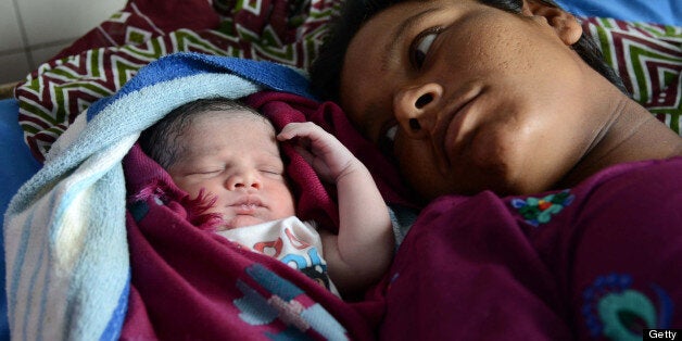 Indian mother Sonia (R) looks on as her newborn baby girl sleeps at a government hospital in Amritsar on July 11, 2013, on the occasion of World Population Day. Africa and Asia are the continents that will see the fastest urban population growth in the next 40 years, a UN report said earlier in the year noting that India and China are leading the surge. The Earth's population is expected to roughly triple by 2050 compared to a century earlier. It stood at three billion in 1950, reached seven billion in 2011 and is likely to reach about 9.5 billion by 2050 -- a rise that will occur especially in the poorest countries, according to UN estimates. AFP PHOTO/NARINDER NANU (Photo credit should read NARINDER NANU/AFP/Getty Images)