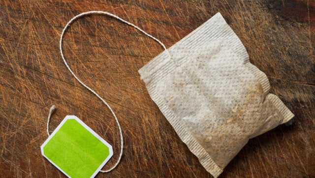 Tea bag on wooden table.