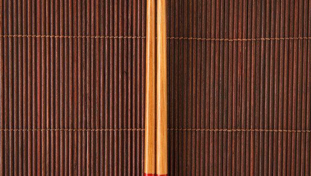 Two chopsticks on a bamboo mat