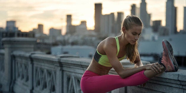 Female stretching hamstrings before run