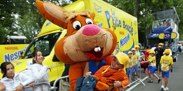 Castres, FRANCE: A person dressed up as Nesquick character holds a child as the advertising caravan passes by during the 12th stage of the 94th Tour de France cycling race between Montpellier and Castres, 20 July 2007. Nesquick is the official supplier since 2006. Tour de France is the opportunity to promote sponsor's products, with more than 15 million spectators each year and over a hundred million television viewers all around the world. AFP PHOTO / JOE KLAMAR (Photo credit should read JOE KLAMAR/AFP/Getty Images)