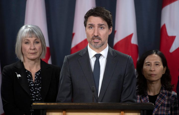 Minister of Health Patty Hajdu and Chief Medical Officer Theresa Tam look on as Justin Trudeau responds to a question in Ottawa on March 11, 2020. 