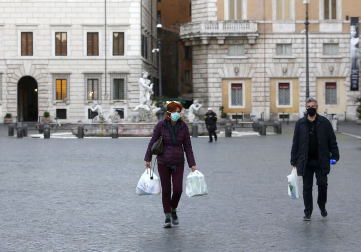 ROME, ITALY - MARCH 11: People wear protective masks in the Piazza Navona in Rome, Italy, on March 11, 2020. Italian government has extended restrictions which was previously limited in the northern Italy, to countrywide with an aim of the Covid-19 outbreak prevention. 