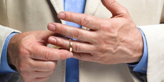 Divorced man taking off wedding ring