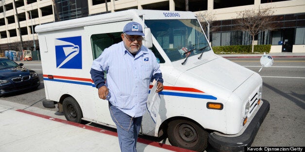 LOS ANGELES, CA - FEBRUARY 06: U.S. Postal Service employee Arturo Lugo delivers an Express Mail package during his morning route on February 6, 2013 in Los Angeles, California. The U.S. Postal Service plans to end Saturday delivery of first-class mail by August, which could save the service $2 billion annually after losing nearly $16 billion last fiscal year. (Photo by Kevork Djansezian/Getty Images)