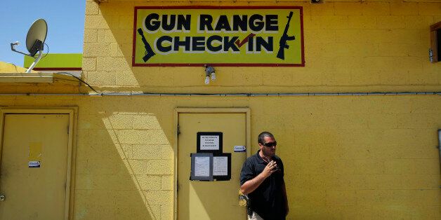 An employee smokes outside of an office for the Last Stop outdoor shooting range Wednesday, Aug. 27, 2014, in White Hills, Ariz. Instructor Charles Vacca was accidentally killed at the range by a 9-year-old with an Uzi submachine gun. (AP Photo/John Locher)