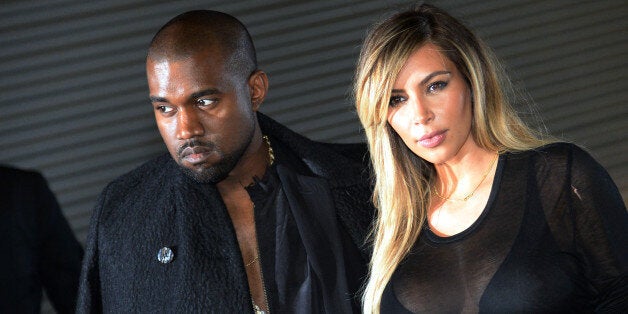 US musician Kanye West and partner Kim Kardashian pose prior to Givenchy 2014 Spring/Summer ready-to-wear collection fashion show, on September 29, 2013 in Paris. AFP PHOTO / PIERRE ANDRIEU (Photo credit should read PIERRE ANDRIEU/AFP/Getty Images)