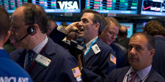 Traders work on the floor of the New York Stock Exchange (NYSE) in New York, U.S., on Thursday, Oct. 17, 2013. U.S. stocks fell, after the Standard & Poor's 500 Index came within four points of a record, as investors assessed the effects of the budget standoff and International Business Machines Corp. and Goldman Sachs Group Inc. tumbled amid declining revenues. Photographer: Scott Eells/Bloomberg via Getty Images