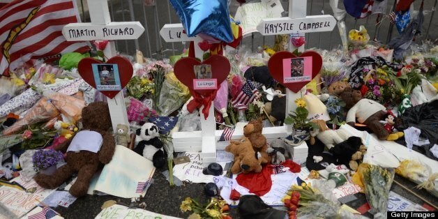 Items and crosses decorate a makeshift memorial April 20, 2013 on Boylston Street, near the scene of Boston Marathon explosions as people get back to the normal life the morning after after the capture of the second of two suspects wanted in the Boston Marathon bombings. Thousands of heavily armed police staged an intense manhunt Friday for a Chechen teenager suspected in the Boston marathon bombings with his brother, who was killed in a shootout. Dzhokhar Tsarnaev, 19, defied the massive force after his 26-year-old brother Tamerlan was shot and suffered critical injuries from explosives believed to have been strapped to his body. AFP PHOTO / TIMOTHY A. CLARY (Photo credit should read TIMOTHY A. CLARY/AFP/Getty Images)