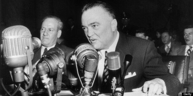 1953: US Federal Bureau of Investigations (FBI) Director J Edgar Hoover sits at a table, speaking into several microphones. (Photo by Hulton Archive/Getty Images)