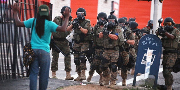 FERGUSON, MO - AUGUST 11: Police force protestors from the business district into nearby neighborhoods on August 11, 2014 in Ferguson, Missouri. Police responded with tear gas and rubber bullets as residents and their supporters protested the shooting by police of an unarmed black teenager named Michael Brown who was killed Saturday in this suburban St. Louis community. Yesterday 32 arrests were made after protests turned into rioting and looting in Ferguson. (Photo by Scott Olson/Getty Images)