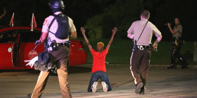 FERGUSON, MO - AUGUST 13: Police surround and detain two people in a car on August 13, 2014 in Ferguson, Missouri. Ferguson is experiencing its fourth day of unrest after following the shooting death of teenager Michael Brown on Saturday. Brown was shot and killed by a Ferguson police officer. (Photo by Scott Olson/Getty Images)