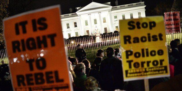 Protesters hold banners during a protest outside the White House in Washington, DC on November 25, 2014, one day after a grand jury decision not to prosecute a white police officer for the killing of an unarmed black teen in Ferguson, Missouri. AFP PHOTO/MLADEN ANTONOV (Photo credit should read MLADEN ANTONOV/AFP/Getty Images)
