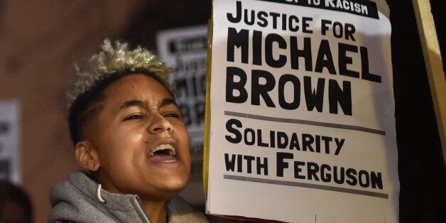 Demonstrators stand and chant with placards during a protest outside the US embassy in London on November 26, 2014 over the US court decision not to charge the policeman who killed unarmed black teenager Michael Brown in the town of Ferguson. The policeman whose killing of unarmed black teenager Michael Brown sparked weeks of riots in the US town of Ferguson will not face charges, the county prosecutor said on November 25, amid mounting anger in the streets. AFP PHOTO / LEON NEAL (Photo credit should read LEON NEAL/AFP/Getty Images)
