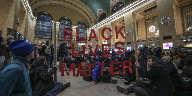 NEW YORK, NY - DECEMBER 7: Protesters hold a banner during a protest at Grand Central Terminal after a grand jury decided not to indict a police officer involved in the death of Eric Garner in July on December 7, 2014 in New York, N.Y. Protests are being staged nationwide after grand juries investigating the deaths of Michael Brown in Ferguson, Missouri and Eric Garner in New York failed to indict the police officers involved in both incidents. (Photo by Bilgin S. Sasmaz/Anadolu Agency/Getty Images)