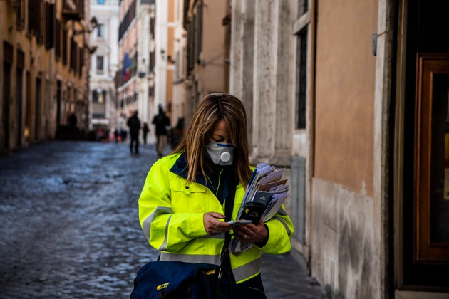 11/03/2020 Roma, una postina a lavoro con la mascherina